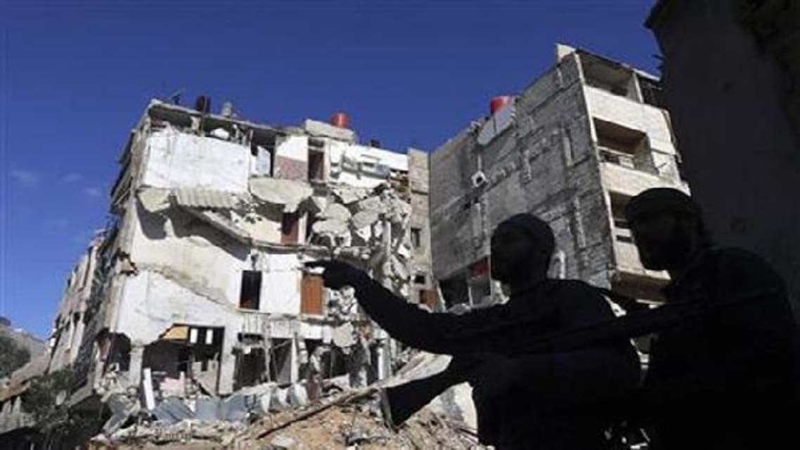 Fighters from the Free Syrian Army stand in front of a house destroyed by an airstrike as they move towards Syrian Army positions in Haresta neighbourhood of Damascus. (Reuters)
