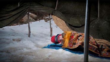 A Syrian child sleeps on the snow in a refugee camp in Lebanon\'s Bekaa Valley. (Courtesy: Facebook)