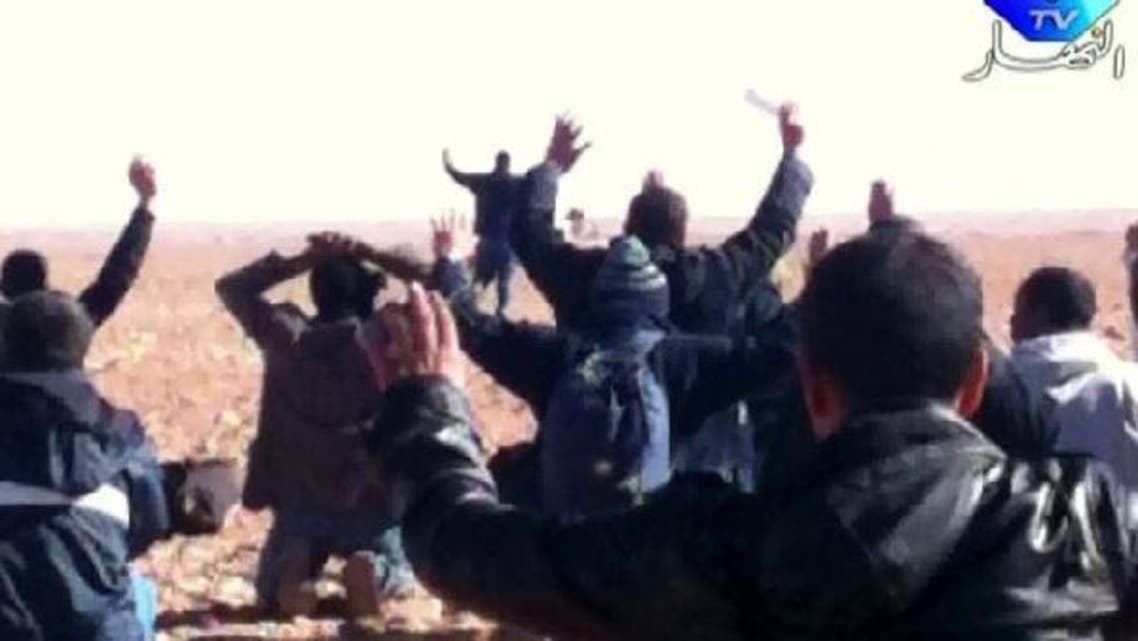 A still image broadcast by Algeria\'s Ennahar TV on January 19, 2013 shows hostages surrendering to Islamist gunmen who overtook a gas facility in Tiguentourine near In Amenas in the south of the country. (AFP)