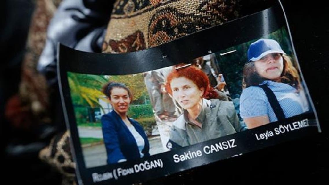 Portraits of presumed victims are seen pinned on a member of the Kurdish community\'s coat at they gather next to the entrance of the Information Centre of Kurdistan in Paris, where three Kurdish women were found shot dead. (Reuters)
