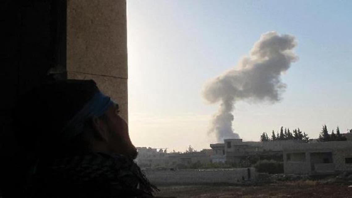 A Free Syrian Army fighter takes position as smoke rises from Taftanaz airport during President Bashar al-Assad\'s forces and the Free Syrian Army clashes in Taftanaz area near Idlib last November. (Reuters)
