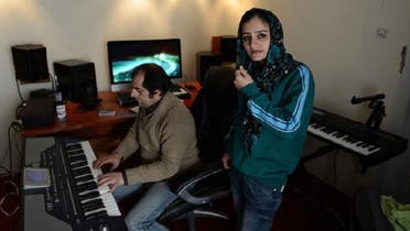 This picture shows Soosan Feroz, 23, (R) Afghanistan\'s first female rap musician, looking on as she practices with Afghan pop musician Farid Rastagar at a recording studio in Kabul. (AFP)