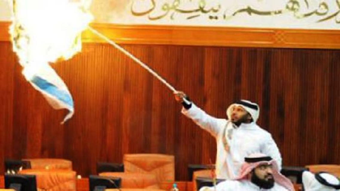 In protest against the recent Israeli war on Gaza, Bahraini lawmaker Osama Al-Tamimi, torches the Jewish state’s flag in parliament. (Photo courtesy Gulf News)