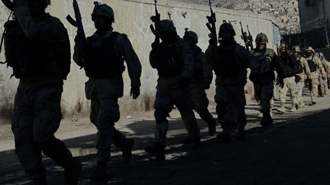 Afghan commandos walk down a road near the Kabul police headquarters building after a clash between Afghanistan forces and Taliban fighters in Kabul on January 21, 2013. (AFP)