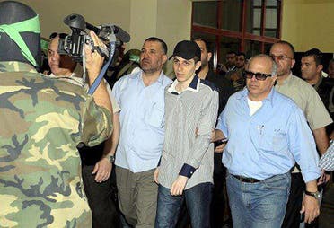 شاليط متوسطاً كلاً من أحمد الجعبرى على اليسار ومدير المخابرات المصرية الأسبق رأفت شحاتة