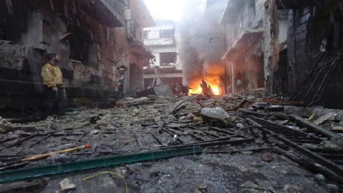 Free Syrian Army fighters are seen as a fire burns after what activists said was a shelling by forces loyal to Syria’s President Bashar al-Assad in Homs. (Reuters)