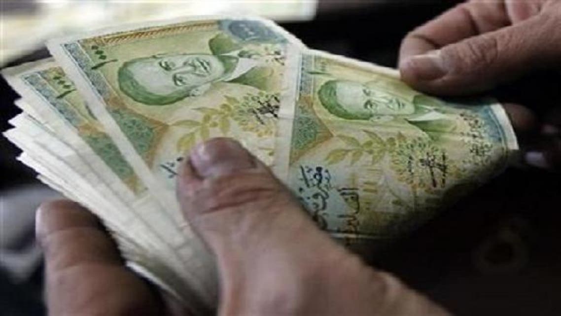 A cashier counts Syrian currency notes in Amman in 2011.The pound is trading at 94 to the dollar on the black market compared to 48 before the uprising. (Reuters)