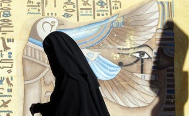 A woman wearing a full veil (niqab) queues near a hieroglyphic mural outside a polling center as she waits to vote during the final stage of a referendum on Egypt’s new constitution in the el-Dokki district of greater Giza, south of Cairo. (File photo: Reuters)