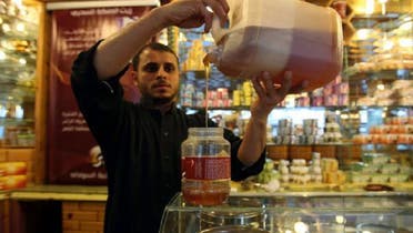 A Yemeni vendor pours honey into a jar at his shop in Sana’ a. (AFP)