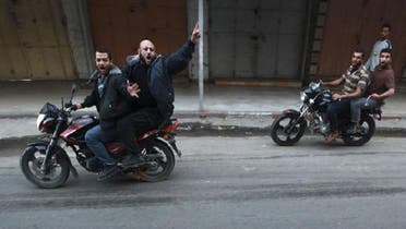 Palestinian gunmen ride motorcycles as the body of a man, who was suspected of working for Israel, was dragged through the streets of Gaza City on Tuesday. (Reuters)