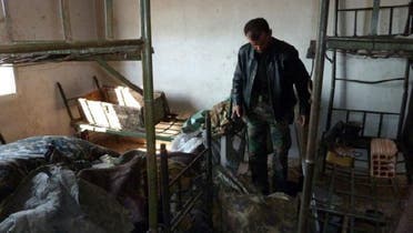 A Syrian rebel fighter chief inspects the damage to a dormitory in the Syrian army Base 46 after its capture, near the northern city of Aleppo, on November 21, 2012. (AFP)