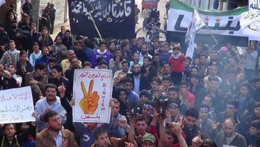 Demonstrators hold a placard that reads, \\"Victory sign over the palace\\" during a protest against Syria\'s President Bashar al-Assad, after Friday prayers in Binsh (REUTERS)