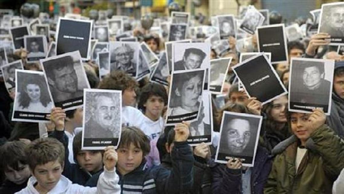 People hold portraits of victims of the terrorist bombing attack against the Argentine Israelite Mutual Association (Amia). (AFP)