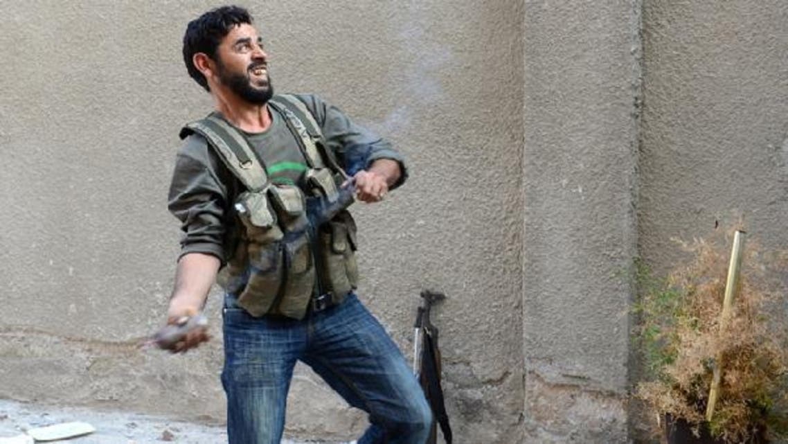 A rebel fighter readies to throw a handmade hand grenade towards pro-Syrian government troops during fighting in the Bustan al-Bashar district of the northern Syrian city of Aleppo. (AFP)