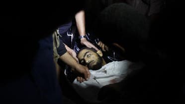 Palestinian gather around the body of an injured Palestinian at the hospital in Beit Lahia, in the northern Gaza Strip. (AFP)