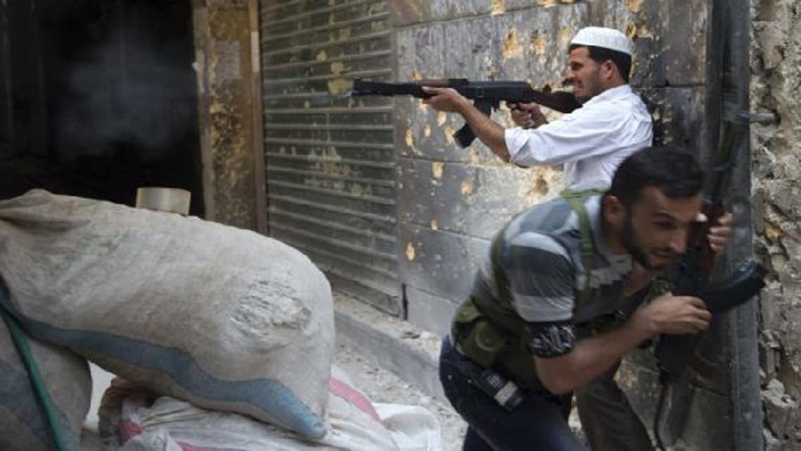 A Syrian rebel fires towards regime forces as his comrade ducks for cover during clashes in the old city of Aleppo in northern Syria. (AFP)