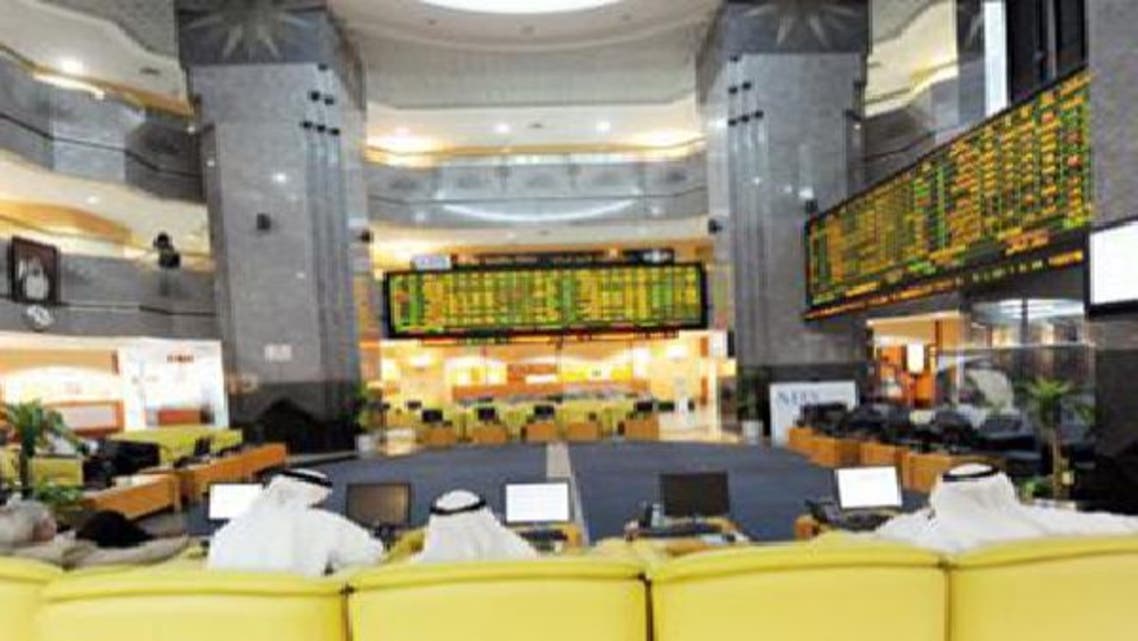 متعاملون يتابعون شاشة التداول في سوق أبوظبي للأوراق المالية