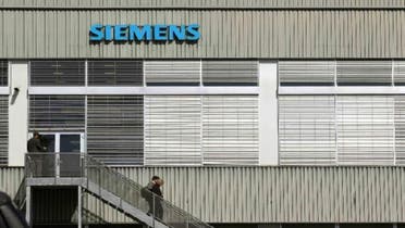 People walk down stairs in front of a building of Siemens Schweiz AG Building Technologies Group, a Swiss unit of German Siemens AG in the central Swiss town of Zug September 20, 2012. (Reuters)