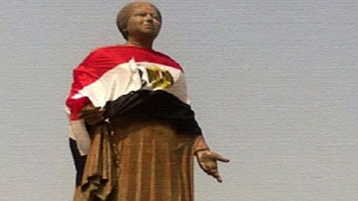 A picture of Umm Kolthoum’s statue after activists cleaned it and painted its base, then wrapped the statue with the Egyptian flag to mark the singer’s patriotism. (Al Arabiya)