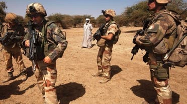 French soldiers stand guard next to a local resident outside Gao, Mali, March 9 2013. (Reuters)