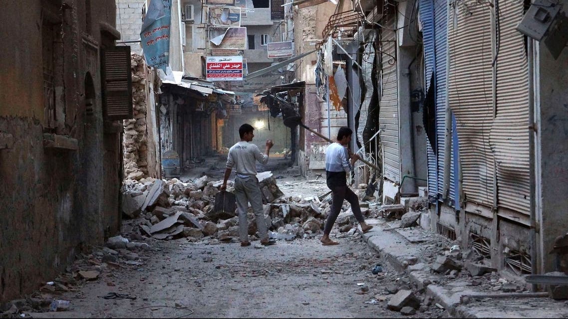 Men clear debris from one of the buildings in Deir al-Zor March 12, 2013. (Reuters)