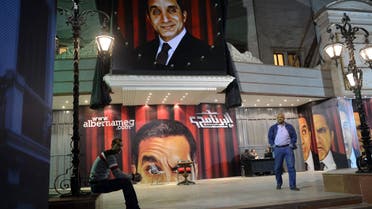 Egyptians walking past posters of TV satirist Bassem Youssef outside a theatre in Cairo. (AFP)