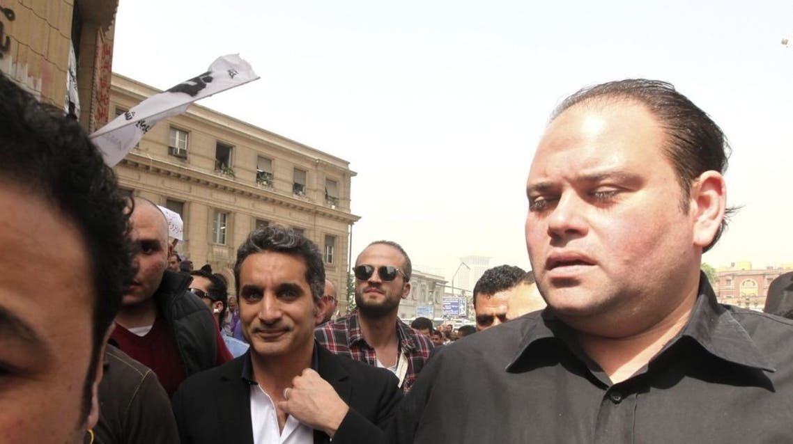 Bodyguards surround Bassem Youssef (C), the country’s best-known satirist, as he arrives at the high court to appear at the prosecutor’s office in Cairo. (Reuters)