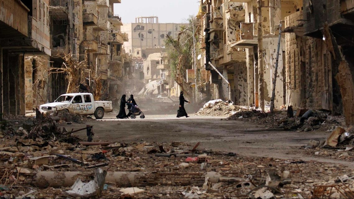 Women walk along a damaged street filled with debris in Deir al-Zor, Syria. Earlier this year, NGO Save the Children warned of increased child abandonment in a special report on the plight of Syria’s youth. (Reuters)