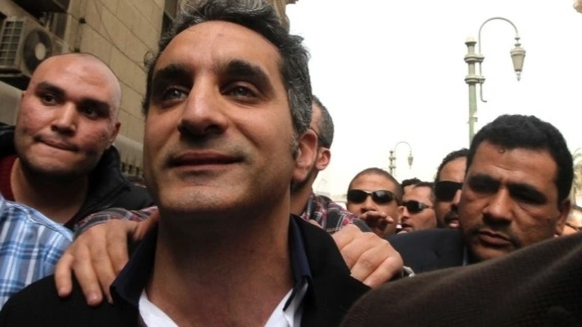 Bassem Youssef, the country’s best-known satirist, gestures to journalists and activists as he arrives at the high court to appear at the prosecutor’s office in Cairo March 31, 2013. (Reuters)