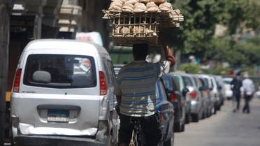 A man carries bread to be sold to customers in Cairo. Ministers in Egypt – which is in talks over a $4.8bn IMF loan - fear possible fuel and food shortages. (Reuters)