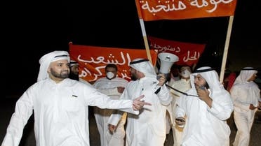 Kuwaiti protesters hold up signs reading, “New government, elected government” during an impromptu protest that was dispersed by tear gas in Sabah al Salem districts November 4, 2012. (Reuters)