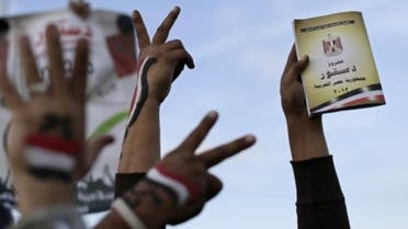 Supporters of President Mohammed Morsi holdsa copy of Egypt's draft constitution during a demonstration in Cairo on Dec. 11, 2012. (Courtesy: AP)