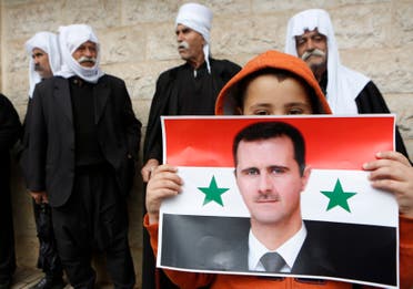 A boy from the Druze community holds a Syrian flag with the image of Syria's President Bashar al-Assad during a rally marking Syria's Independence Day. (File photo: Reuters)
