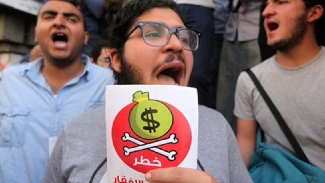 Egyptian protesters hold placards with the Arabic inscription reading "danger" as they demonstrate against the IMF. (Reuters)