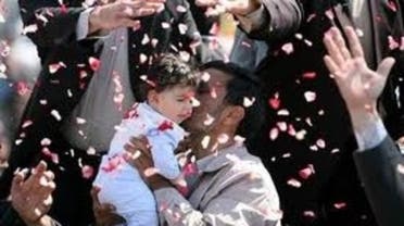 Iran's President Mahmoud Ahmadinejad hugs a child and is showered with flower petals during his visit to Semnan, Iran, in 2009. AP