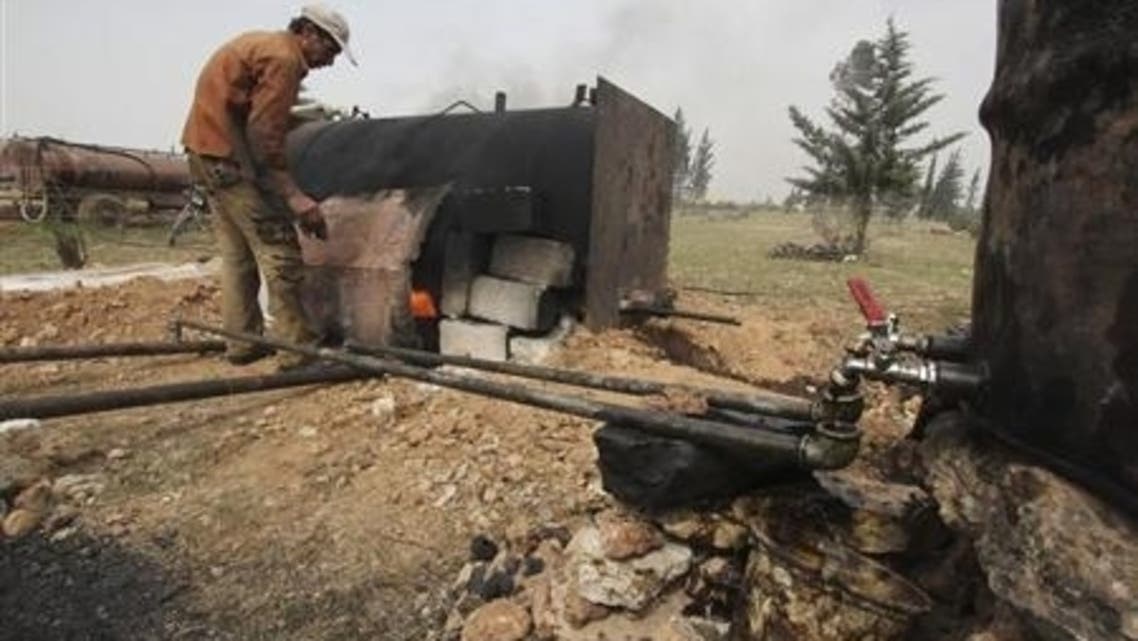 A man works at a makeshift oil refinery site in Aleppo's countryside April 2, 2013.