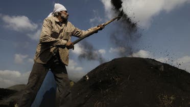 A Palestinian worker covers a hole producing smoke from under a pile of smoldering wood during the process of turning wood into coal at one of the few local charcoal manufacturing plants east of Gaza City on April 23, 2013. (AFP)A Palestinian worker covers a hole producing smoke from under a pile of smoldering wood during the process of turning wood into coal at one of the few local charcoal manufacturing plants east of Gaza City on April 23, 2013. (AFP)