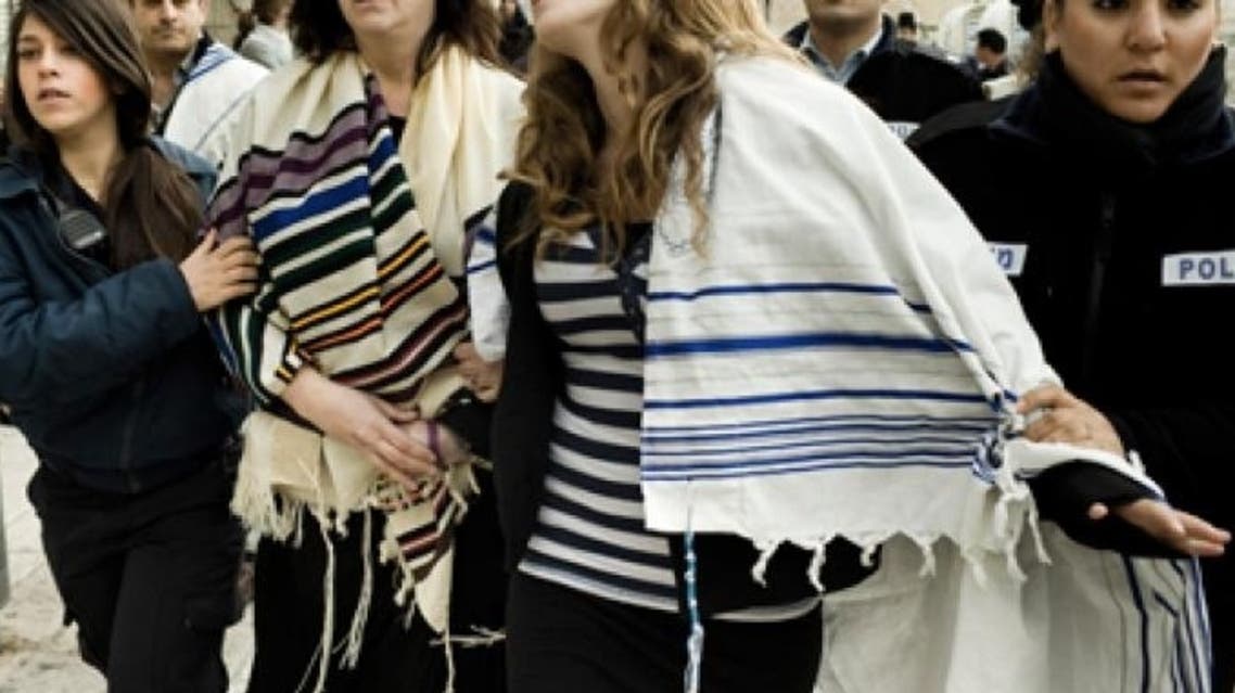 Israeli police arrest American Rabbi Susan Silverman (L), sister of comedian Sarah Silverman, and her teenage daughter Hallel Abramowitz (C), after performing Rosh Hodesh prayers at the Western Wall ina Jerusalem, on February 11, 2013 (AFP)