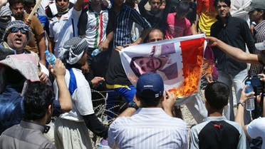 Iraqi Sunni Muslims burn a poster of Iranian President Mahmoud Ahmadinejad during an anti-government demonstration in Falluja, 50 km (31 miles) west of Baghdad April 26, 2013. (REUTERS)