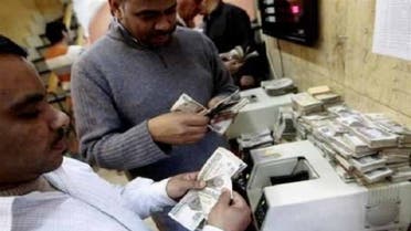 Men count bank notes at a foreign exchange office in the center of Cairo. Qatar wants 5 percent interest on $3 billion in bonds it has offered to buy from Egypt, an Egyptian official said. (Reuters)