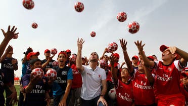 Martin Keown (C), a former British soccer player for Arsenal, and Syrian refugee children throw balls into the air during the official opening of Save the Children's new soccer field at the Al Zaatri refugee camp in the Jordanian city of Mafraq, near the border with Syria, May 2, 2013. Keown's visit is part of soccer club Arsenal's global partnership with humanitarian group Save the Children's education projects. (Reuters)