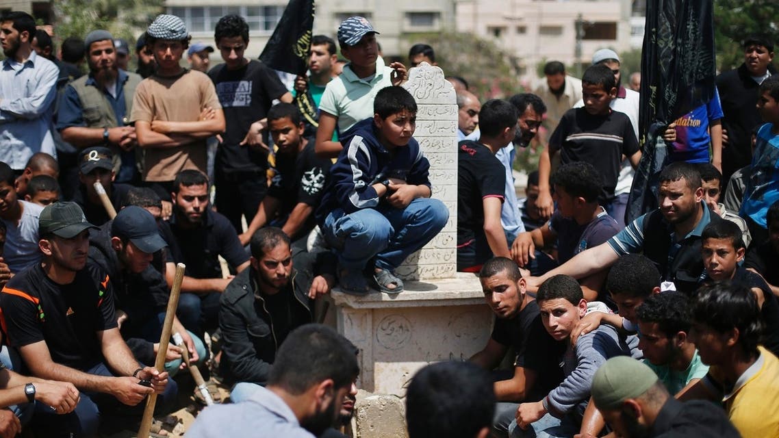 Palestinians sit around the grave of Haitham Al-Mes-hal, who relatives said belonged to a militant Jihadist Salafi organisation, after his burial at a cemetery in Gaza City April 30, 2013. (Reuters)
