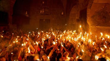 Christian Orthodox worshippers hold up candles lit from the 'Holy Fire' as thousands gather in the Church of the Holy Sepulchre in Jerusalem's old city on May 4, 2013 AFP