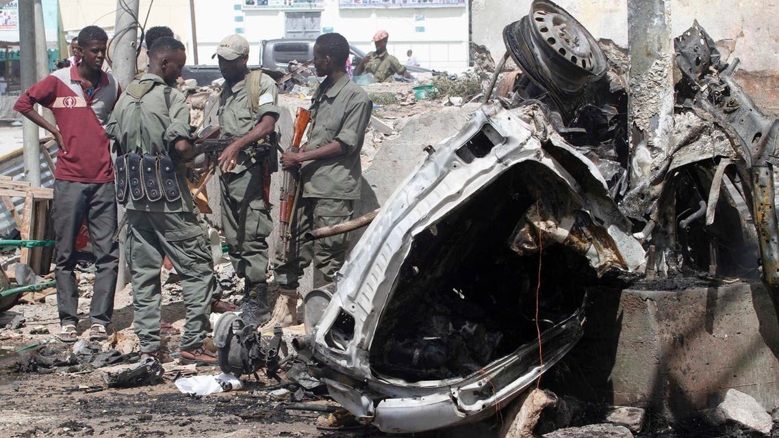 Officers stand by the remains of a wrecked car at the scene of car bomb explosion along the "Kilometre 4" road junction, south of the capital Mogadishu, May 5, 2013. (Reuters)