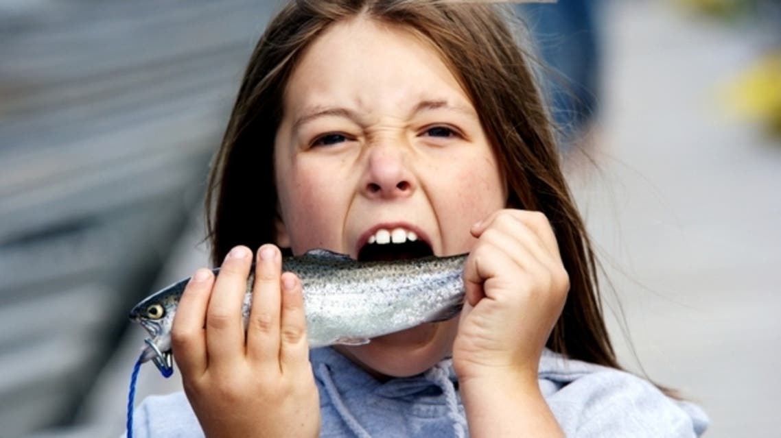 eating fish طفل يأكل سمك