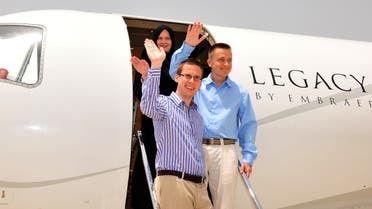 A Finnish couple and an Austrian student (front) abducted in Yemen by Al-Qaeda militants wave on May 9, 2013 as they leave the airport of the Omani capital Muscat. (AFP)