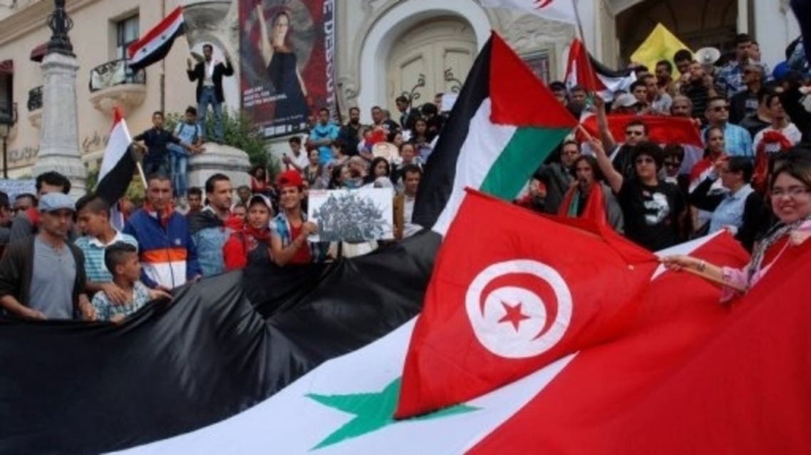 Tunisian protestors hold Syrian flags AFP