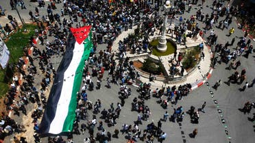 Palestinians carry a giant Palestinian flag through central Ramallah during a rally to mark Nakba Day in the West Bank city of Ramallah May 15, 2013. (Reuters)