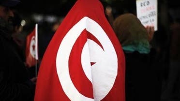 A female protester wears a Tunisian flag in front of the Prime Minister's office during a demonstration in downtown Tunis, January 21, 2011. (Reuters)