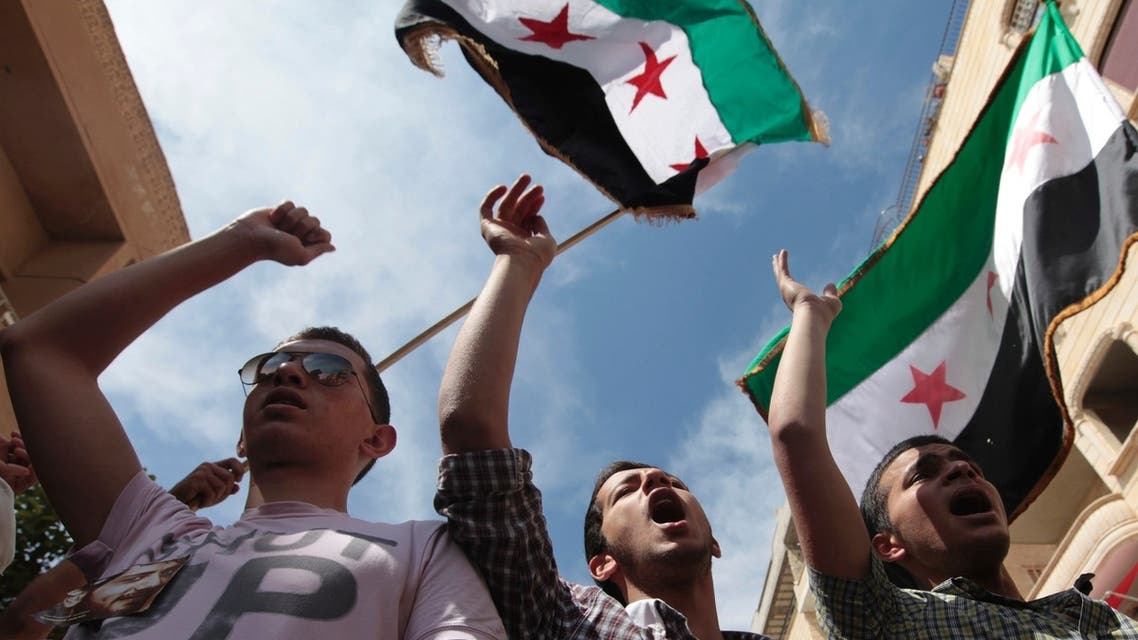 Demonstrators chant slogans and wave Syrian opposition flags during a protest against President Bashar al-Assad after Friday prayers in Raqqa province, east Syria, May 17, 2013. REUTERS